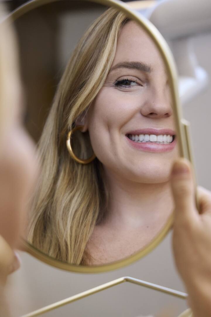 Paciente observando o sorriso no espelho